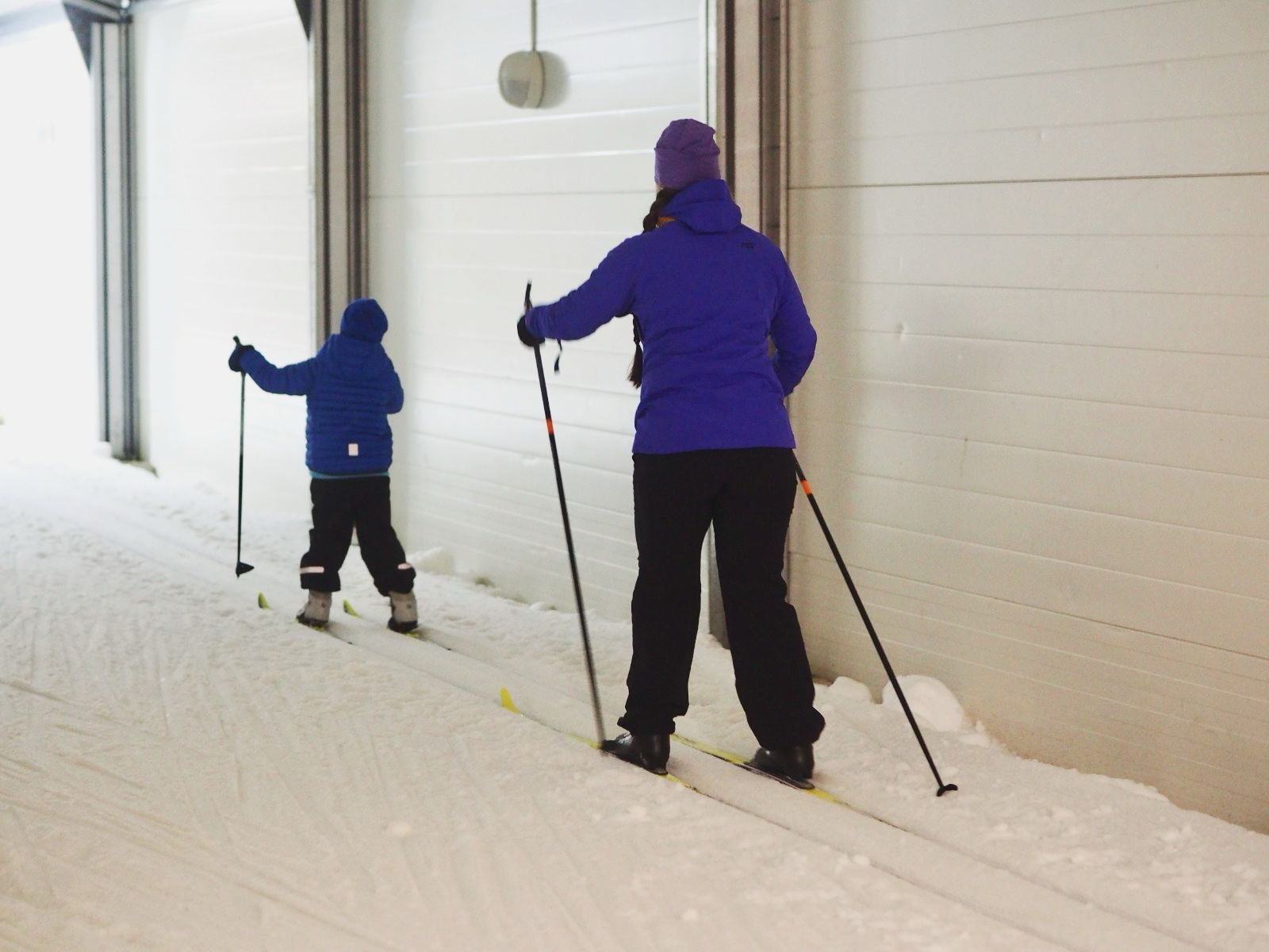 Lapsi ja aikuinen hiihtävät hiihtoputkessa.