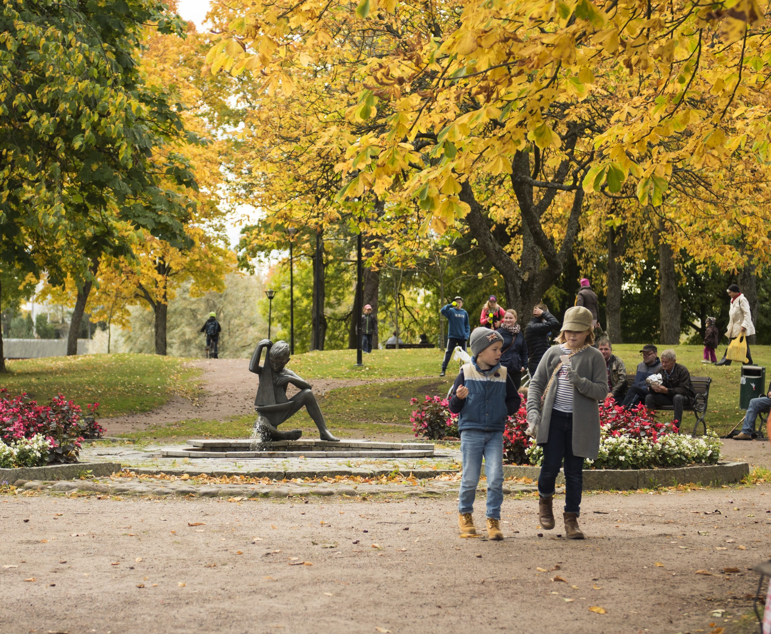 Syksyinen Rauhanpuisto, puissa keltaiset lehdet ja kävelevät lapset.